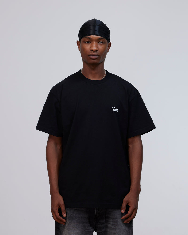 Model wearing the black Patta Championship cotton T-shirt with a white script logo on the chest.