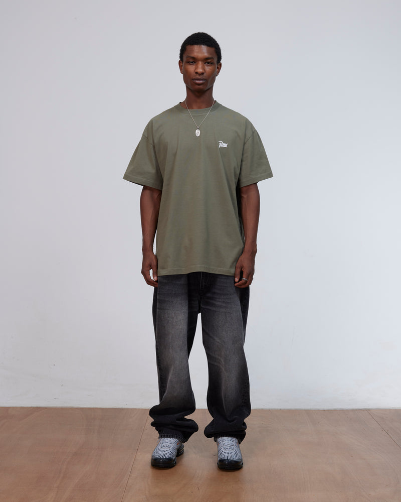Front view of a model wearing the Patta Championship T-Shirt in dusty olive cotton jersey.
